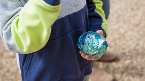 A close up of a child's hands holding a wrapped chocolate egg after the Easter trail at Osterley Park and House, West London
